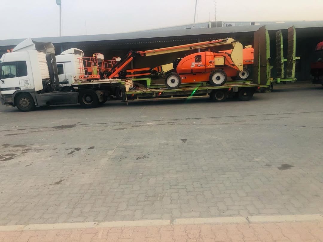 JLG boom lift on flatbed trailer at port warehouse